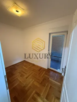 Empty room with parquet flooring and balcony access. - image 2