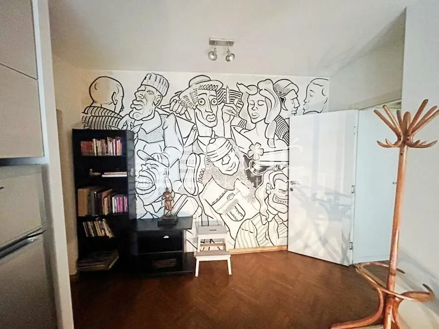Living room with parquet flooring and a painted wall.
