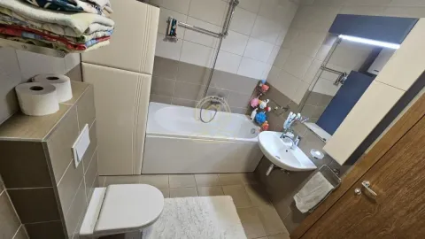 Bathroom equipped with a bathtub, washbasin, toilet, and mirror. - image 16