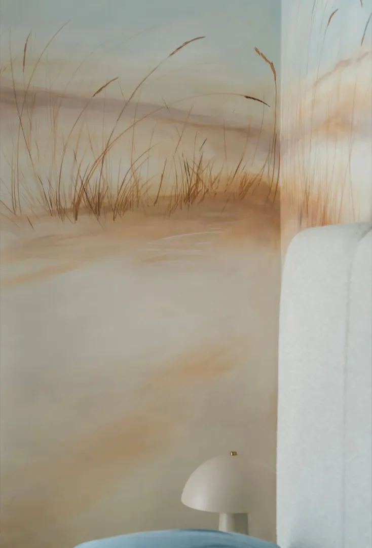 Bedroom detail with a painted wall and a bedside lamp.
