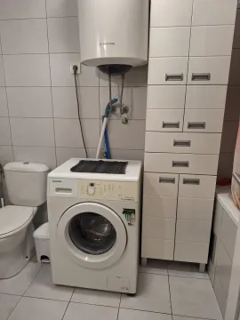 Manje kupatilo opremljeno sanitarijama, mašinom za veš i ormarićem. - image 6