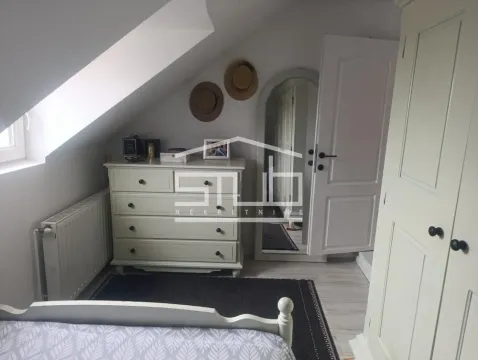 Attic bedroom with a white dresser, wardrobe, and bed. - image 7