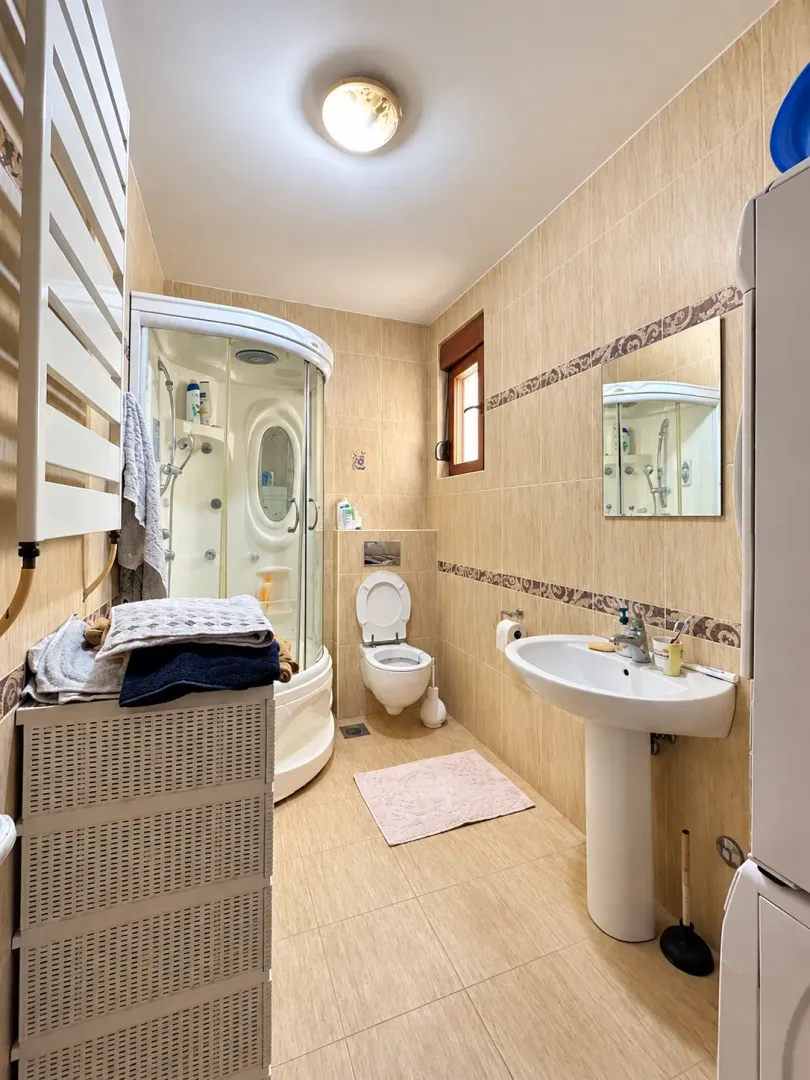 Kupatilo opremljeno tuš kabinom, umivaonikom i WC šoljom.