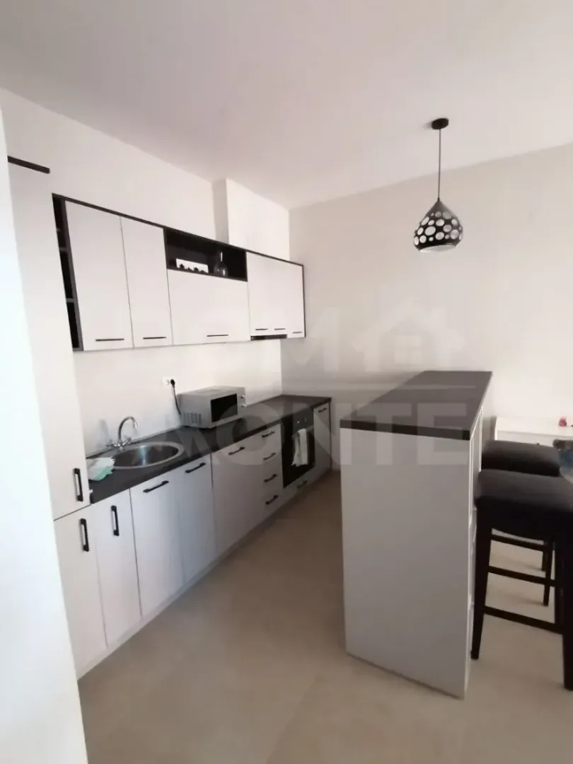 Modern kitchen with white cabinets and a breakfast bar.