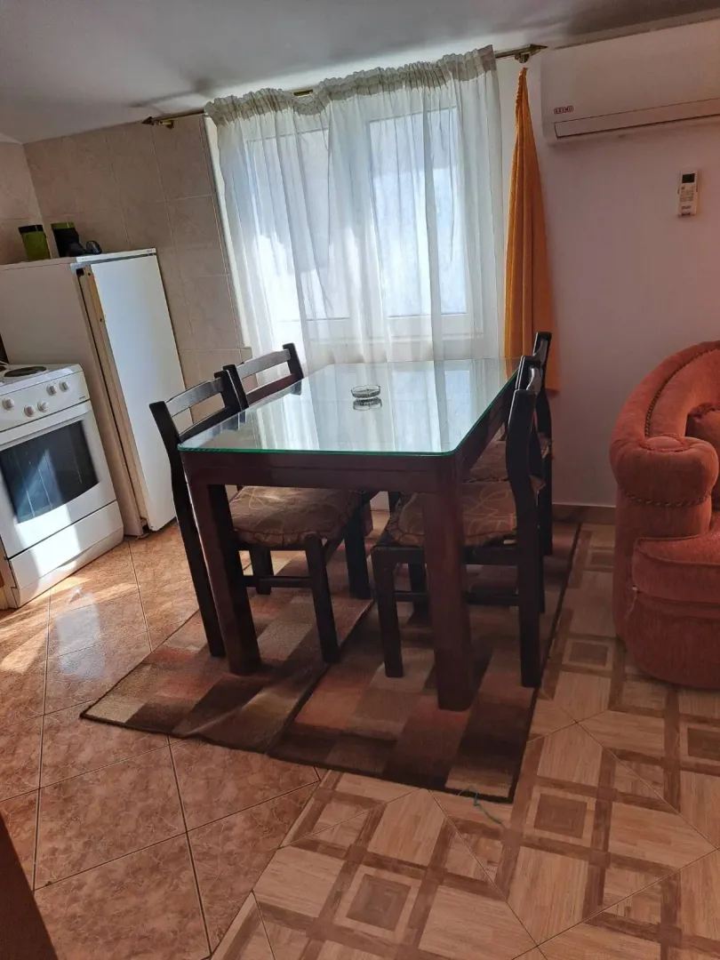 Living room with a dining table and chairs, next to the kitchen.