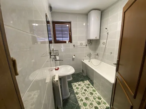 Bright bathroom featuring a bathtub, sink, and white tiles. - image 8