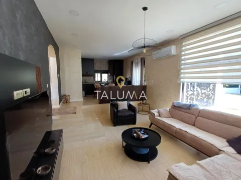 Living room with a sofa set and a view of the kitchen in the background. - image 3