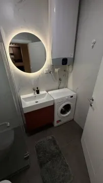 Kupatilo sa umivaonikom, veš mašinom, bojlerom i okruglim ogledalom sa pozadinskim osvjetljenjem. - image 9