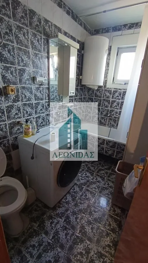 Kupatilo sa pločicama, kadom, WC šoljom, mašinom za veš i bojlerom.