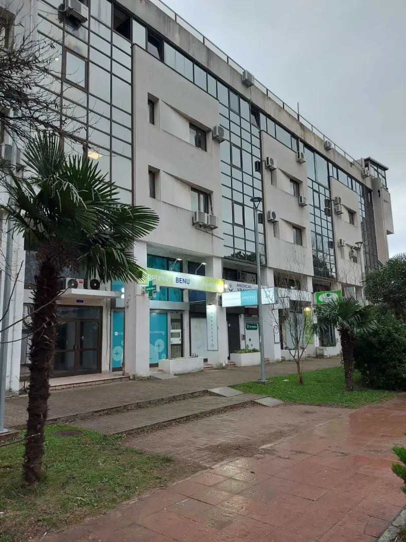 Exterior of a multi-story building with commercial spaces on the ground floor.