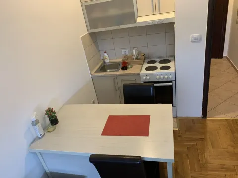 A small functional kitchen with a dining table. - image 8