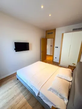 Moderna spavaća soba sa bračnim krevetom, garderoberom i zidnim televizorom. - image 7