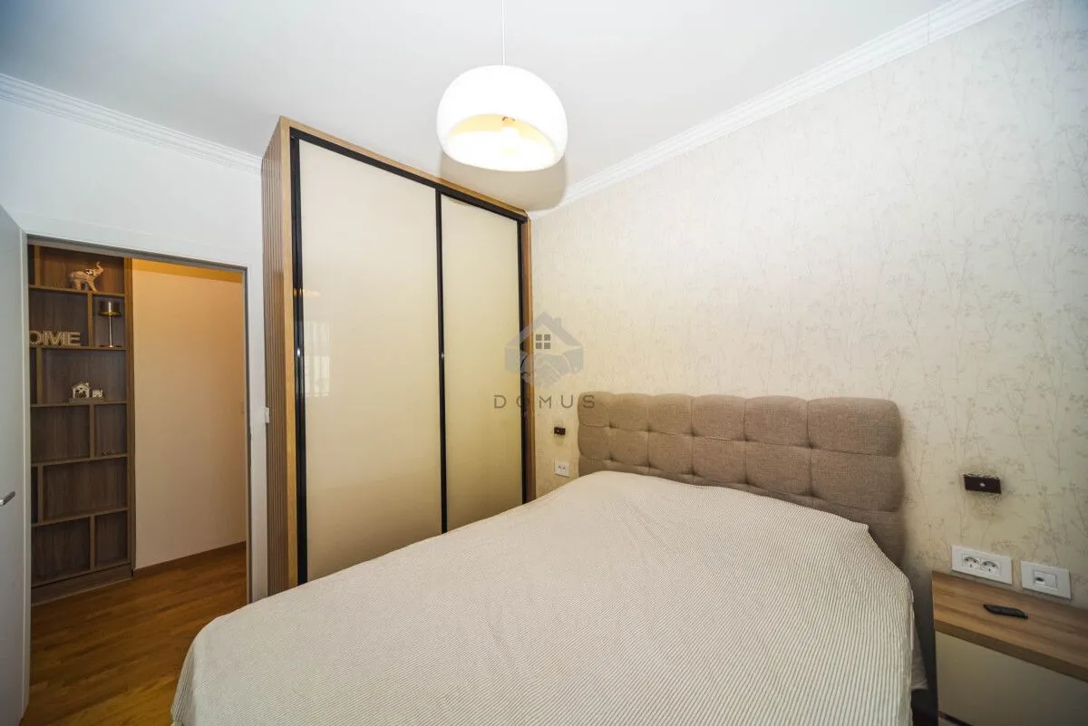 Furnished bedroom with a double bed and a fitted wardrobe.