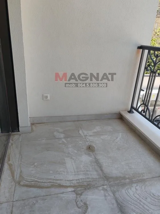 Pogled na nenamestenu terasu sa keramičkim pločicama i ogradom.