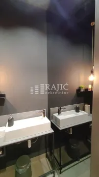 Modernly equipped bathroom with two washbasins and dark walls. - image 7