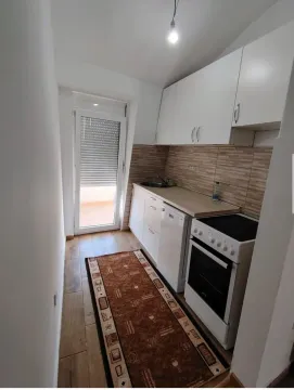 Small kitchen with white units and access to the terrace. - image 2
