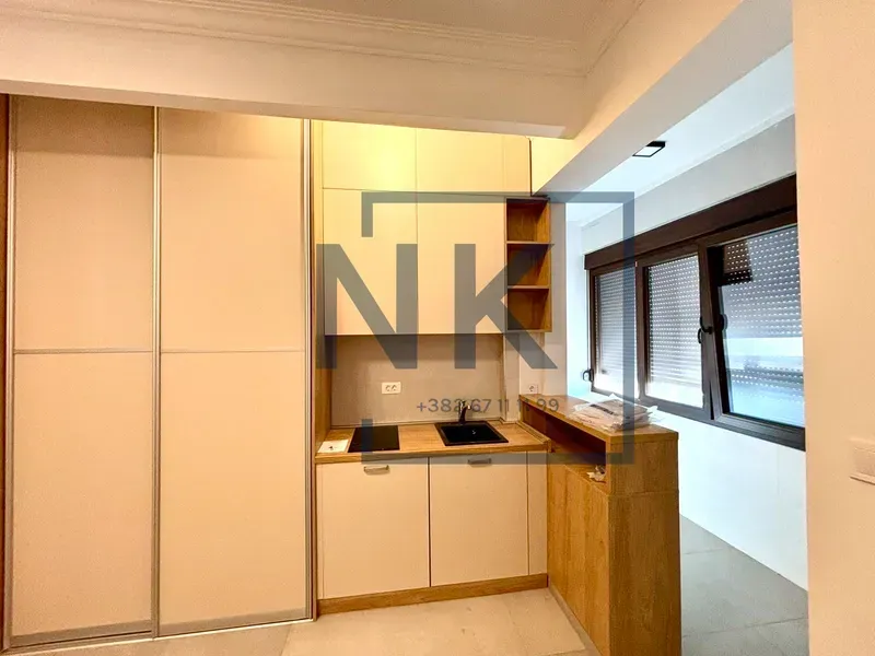 Small kitchen with a built-in wardrobe and a sink by the window.