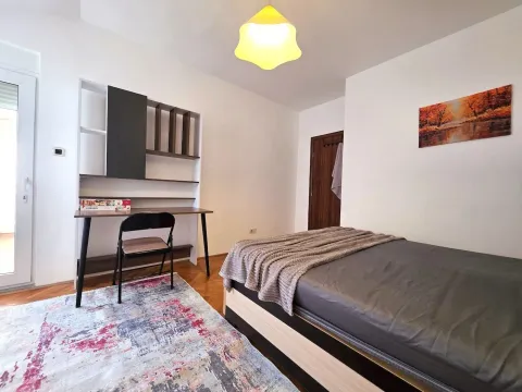 Furnished bedroom with a bed, desk, and rug. - image 17
