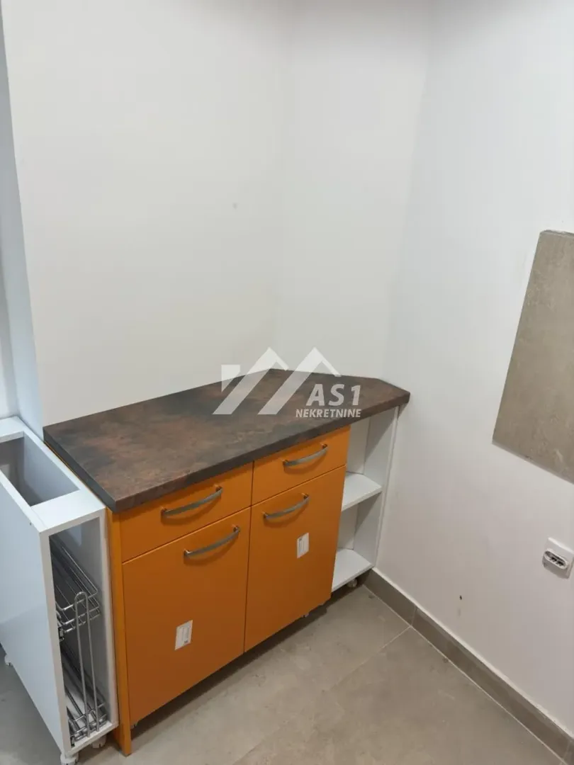 Small kitchen unit with orange fronts and a countertop.
