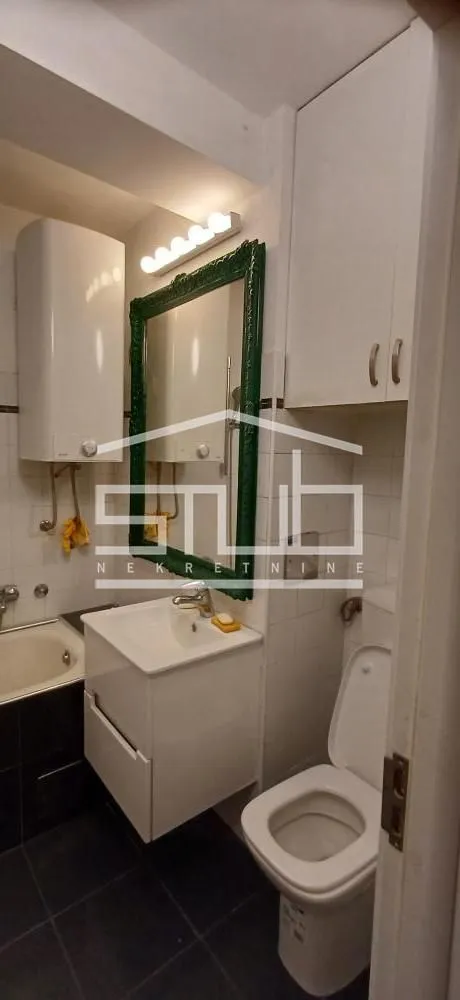 Kompaktno kupatilo sa umivaonikom, ogledalom, WC šoljom i bojlerom.