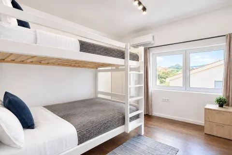 Bright bedroom with a bunk bed and a window. - image 15