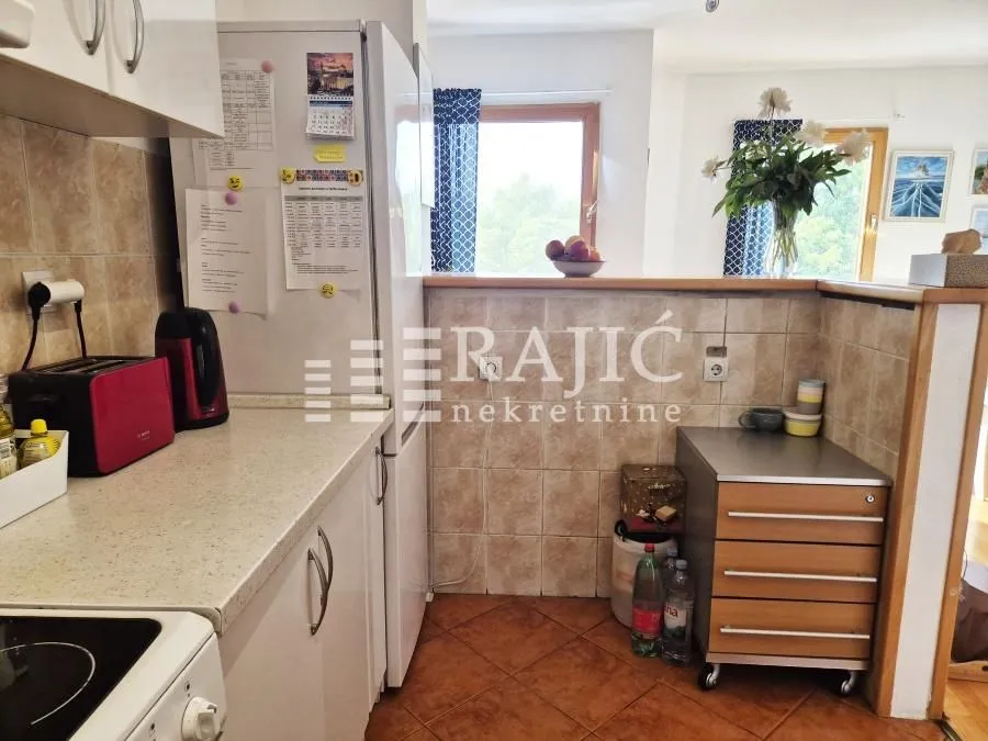 View of part of the kitchen with countertops and a refrigerator.
