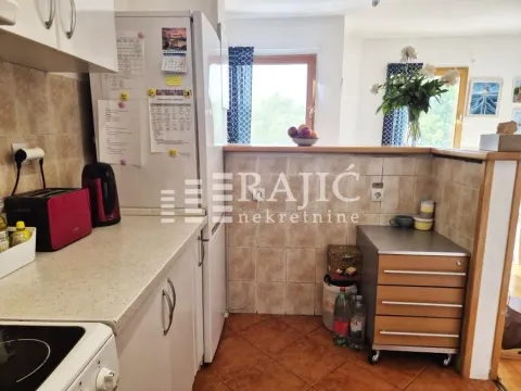 View of part of the kitchen with countertops and a refrigerator. - image 6