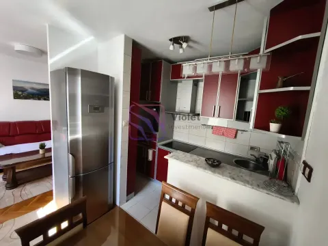 Moderna kuhinja sa tamno-crvenim elementima i ugrađenim frižiderom. - image 3