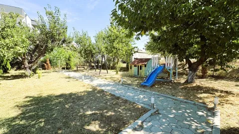 Dvorište sa stazom, drvećem i dečjim igralištem. - image 11