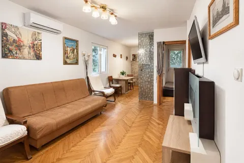 Dnevna soba sa garniturom, drvenim parketom i trpezarijskim dijelom u pozadini. - image 3