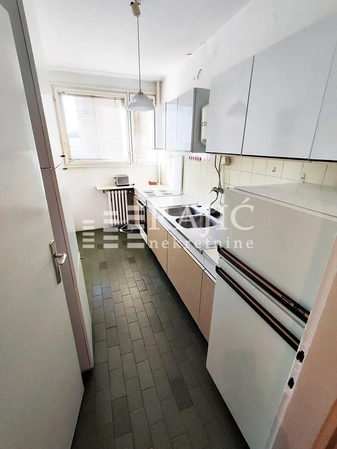 Small kitchen with white cabinets and a refrigerator.