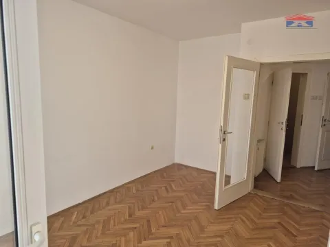 Prazna soba sa parketom i otvorenim vratima. - image 2
