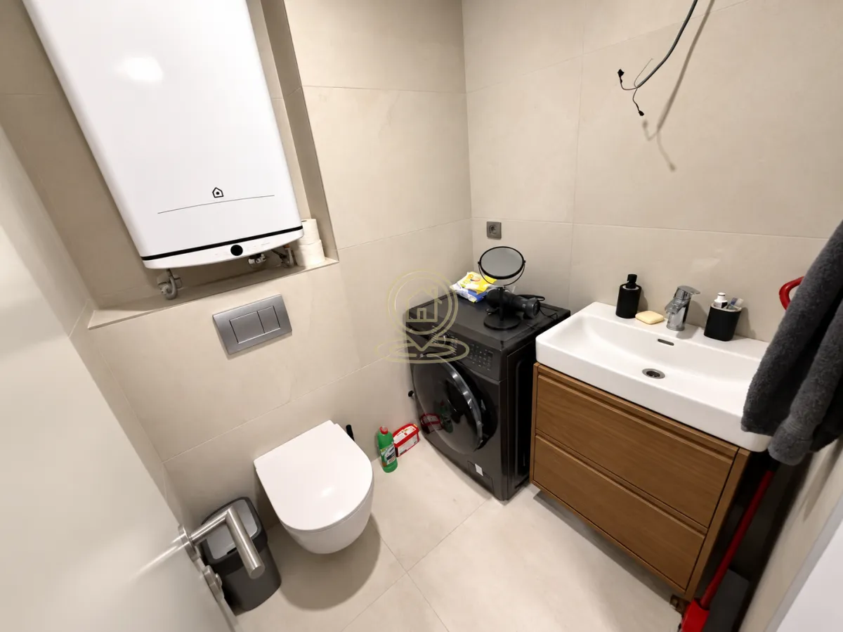Modern bathroom with a toilet, washbasin, and installed water heater.