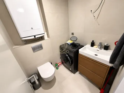 Modern bathroom with a toilet, washbasin, and installed water heater. - image 5