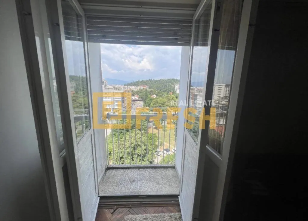 Pogled sa balkona na grad i okolno zelenilo.