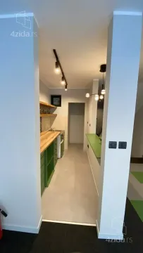 View of a small kitchen with green cabinetry and a wooden countertop. - image 4