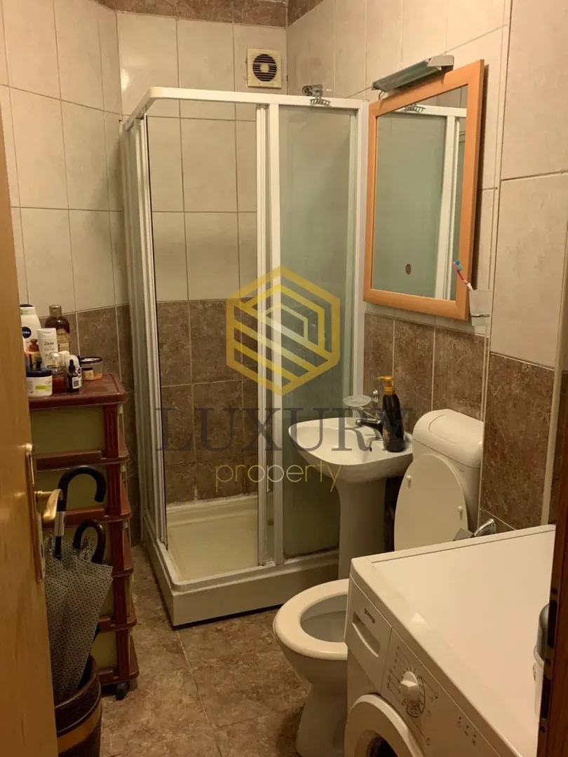 Smaller bathroom with a shower cabin, washbasin, and toilet.