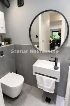 Manje kupatilo sa modernim umivaonikom, WC šoljom i okruglim ogledalom. - image 13