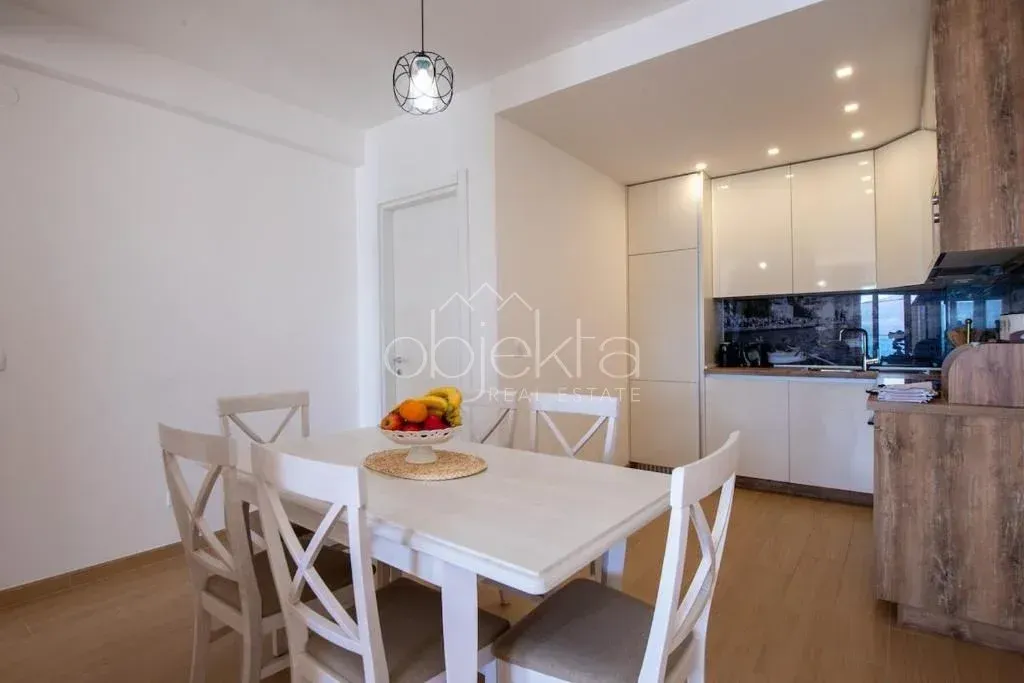 Modern kitchen with a dining area featuring a white dining table and chairs.