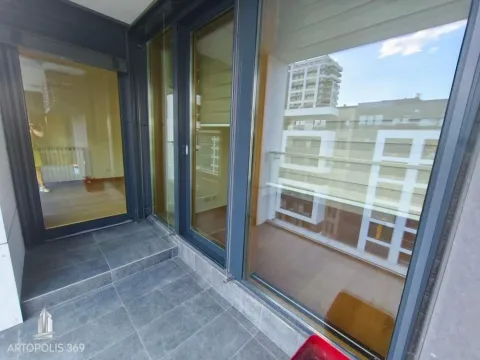 Natkriveni balkon sa tamnim pločicama i velikim staklenim površinama. - image 13