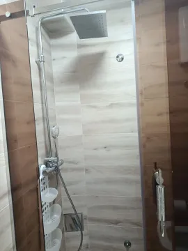A shower enclosure with a modern faucet and ceramic tiles in the bathroom interior. - image 13