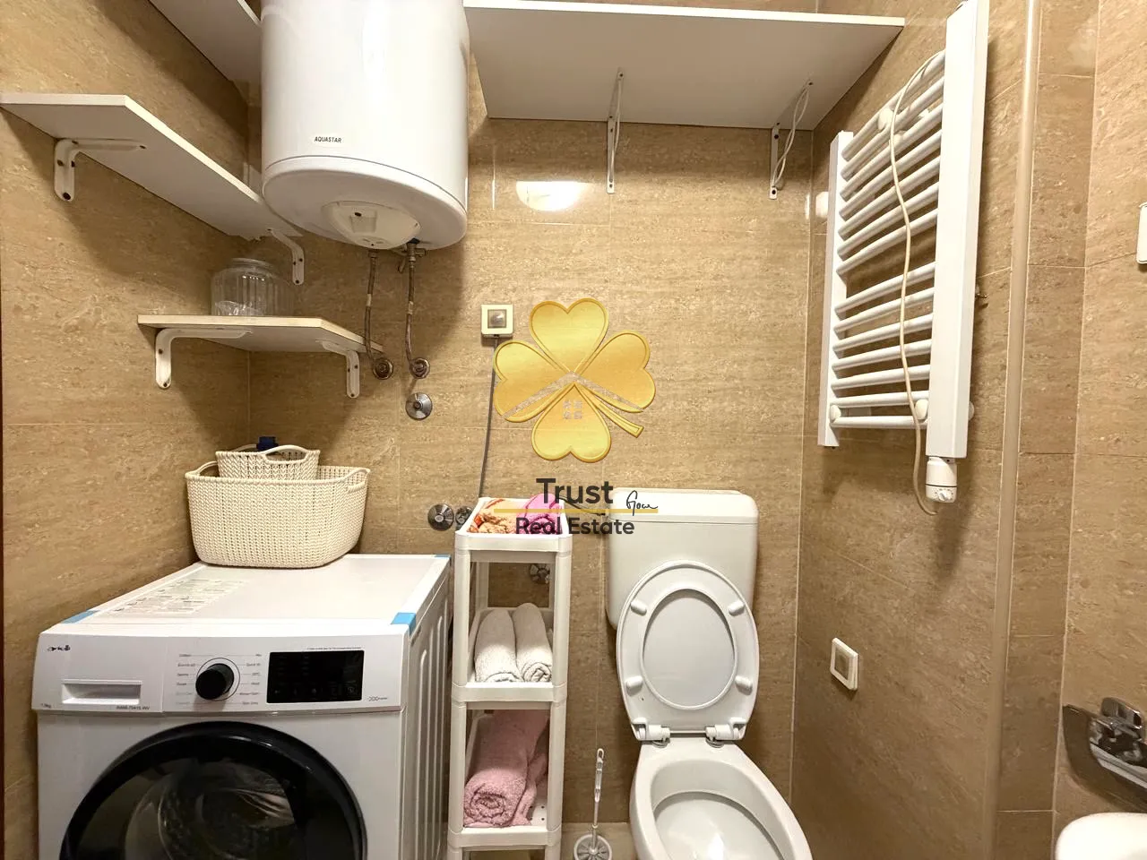 Small bathroom with washing machine, toilet, and water heater.