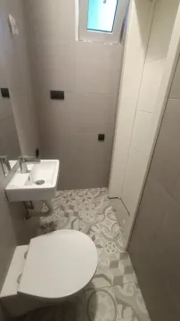 Manje kupatilo sa umivaonikom, šoljom i pločicama sa dezenom. - image 16