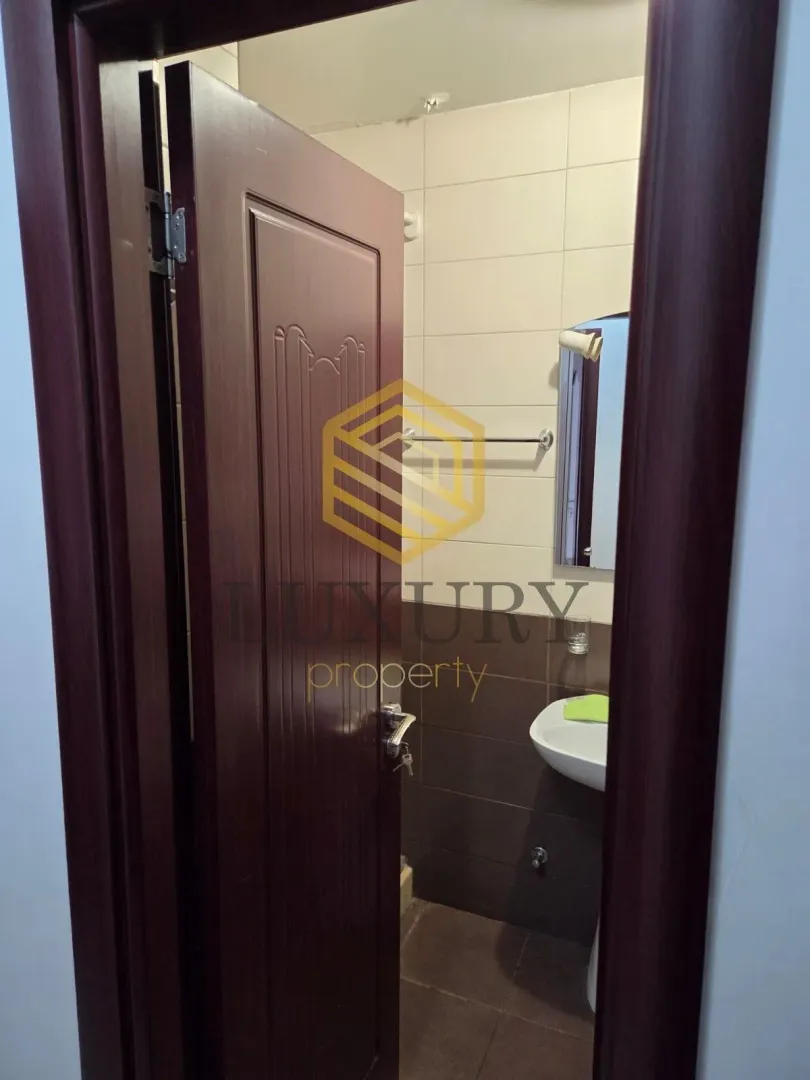 View of a small bathroom through an open door.