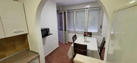 Trpezarija sa stolom i stolicama povezana sa kuhinjom. - image 6