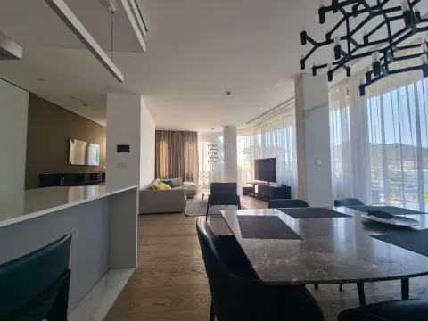 Spacious living room connected to the dining area and kitchen, featuring large windows with a sea view. - image 12