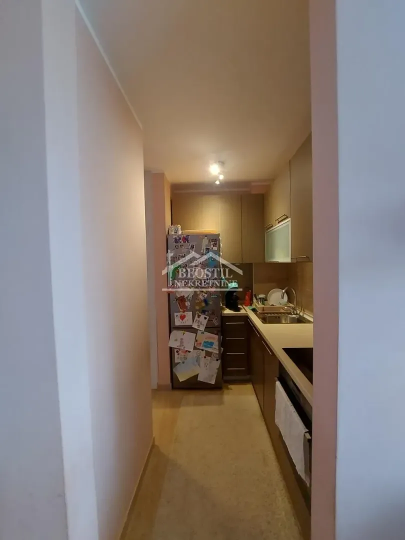Small kitchen with cabinets and a refrigerator.
