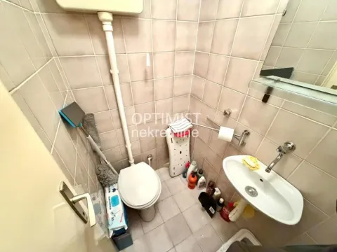 Manje kupatilo obloženo keramičkim pločicama sa toaletom i umivaonikom. - image 18