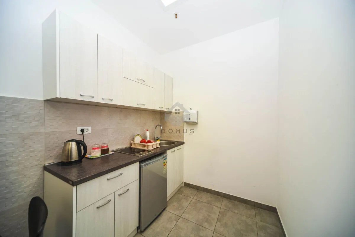 Smaller kitchen with white cabinetry and a sink.