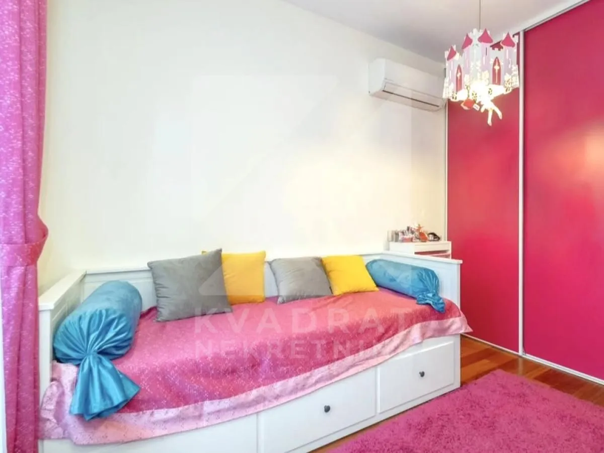 Dječja spavaća soba sa krevetom i roze garderoberom.